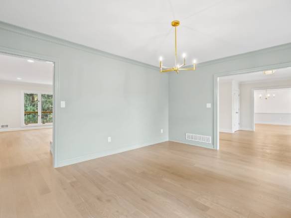 Bright and spacious living room with light-colored walls and hardwood floors.
