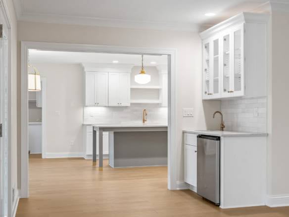 Bright modern kitchen with white cabinets and gold fixtures.
