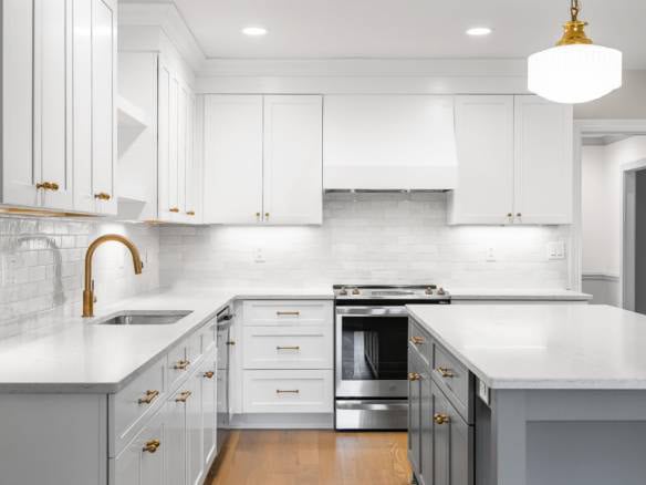 Elegant kitchen with white cabinets, gold hardware, and a central island.