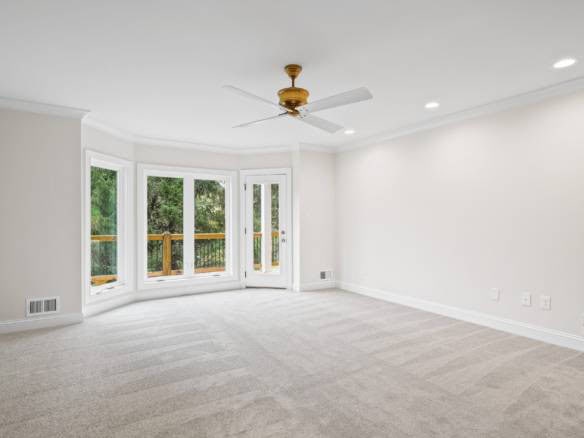Modern living room featuring large bay windows and neutral decor.