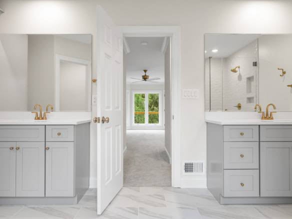Dual vanity bathroom with mirrors and gold fixtures at 11714 Paramont Way.