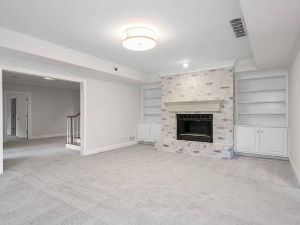Modern living room featuring a white brick fireplace and built-in shelves.
