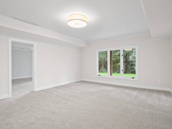 Interior living room with spacious layout and large window overlooking greenery.