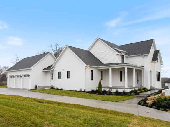 New white house with large driveway and landscaped yard in Hidden Falls Drive.