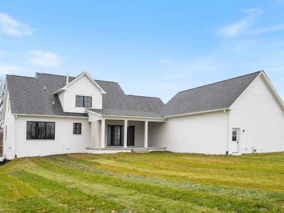 Modern white house with a large, well-maintained backyard and a covered porch, situated at 3979 Hidd.