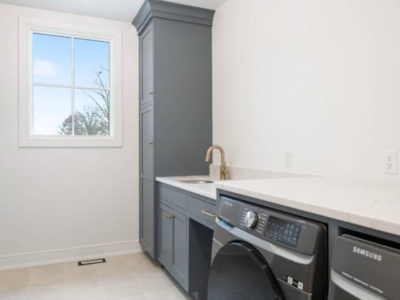 Laundry room with gray cabinetry, white countertops, and a Samsung washer.
