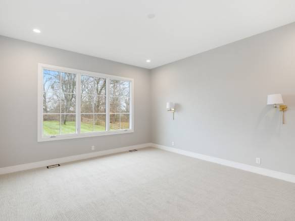 Bright, spacious living room with large window and neutral decor.