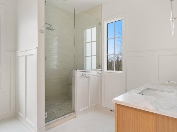 Modern bathroom with walk-in shower, white walls, and natural light at 3979 Hidden Falls Drive.
