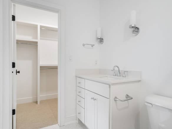Laundry room with white cabinets, sink, and closet space at 3979 Hidden Falls Drive.
