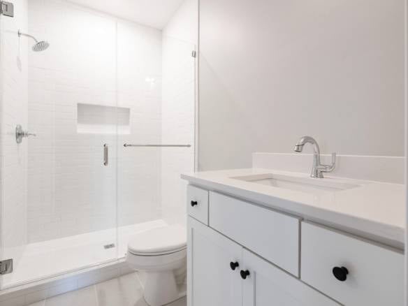 Modern bathroom with walk-in shower and white vanity.