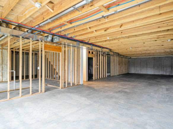 Garage interior with wooden framing and concrete floor.