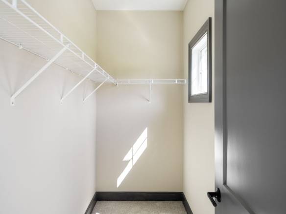 Closet with white wire shelving and a small window for natural light.