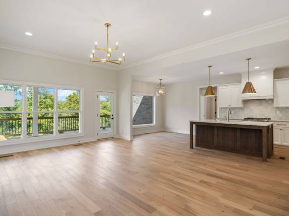 Spacious interior with large windows, hardwood floors, and contemporary lighting in a newly renovate.
