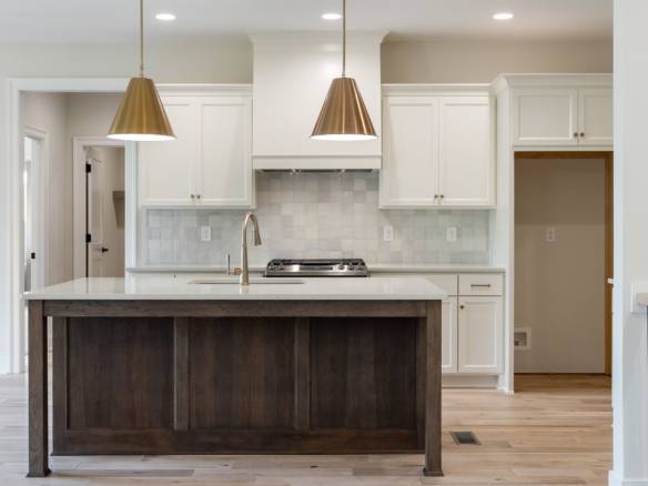 Modern kitchen with white cabinets and a dark island at 6307 Leyton Court.
