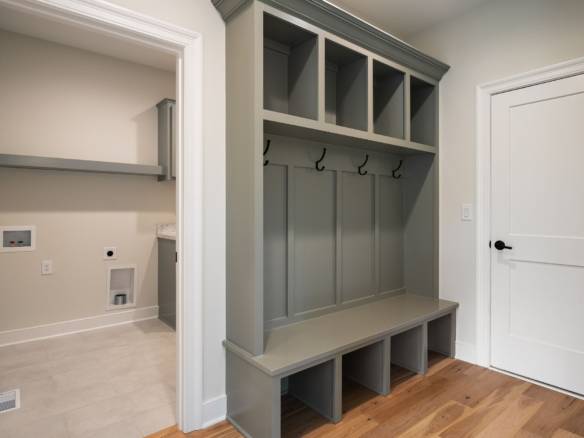 Custom mudroom with storage bench, hooks, and cubbies in a contemporary home.