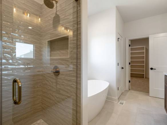 Modern bathroom with a glass shower, freestanding tub, and sleek fixtures.