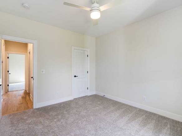 Interior view of a newly renovated room at 6307 Leyton Court, showcasing fresh paint, a ceiling fan,.
