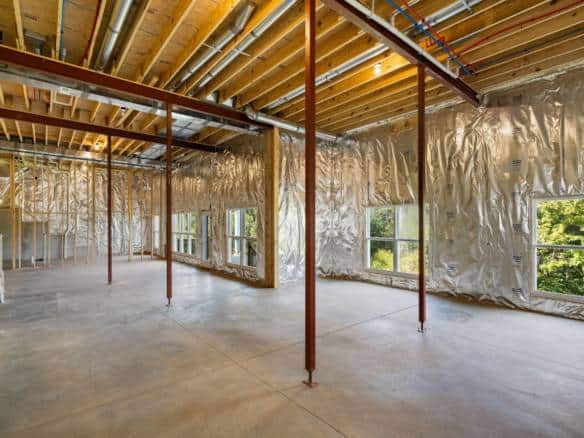 Construction site of a new residential building with exposed framing and insulation.