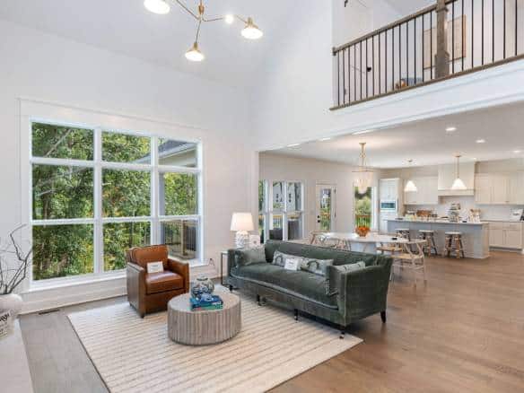 Spacious living room featuring large windows, high ceilings, and contemporary furniture in a newly r.