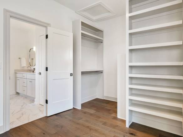 Walk-in closet with custom shelving and ample storage.