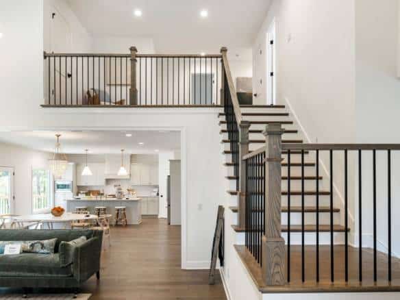 Spacious living area with open kitchen, staircase, and high ceilings.