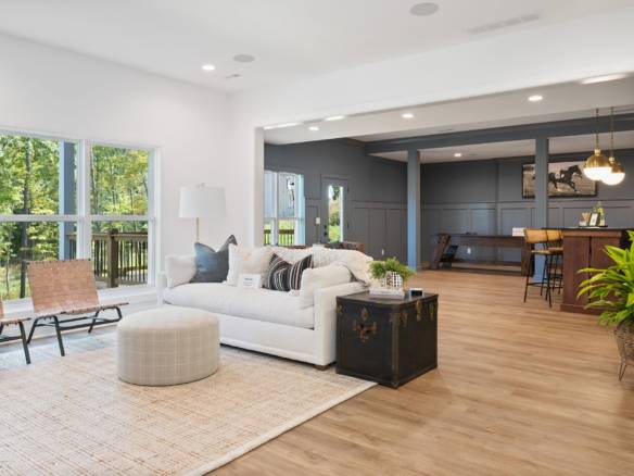 Spacious living room featuring large windows, modern decor, and seamless transition to the kitchen a.