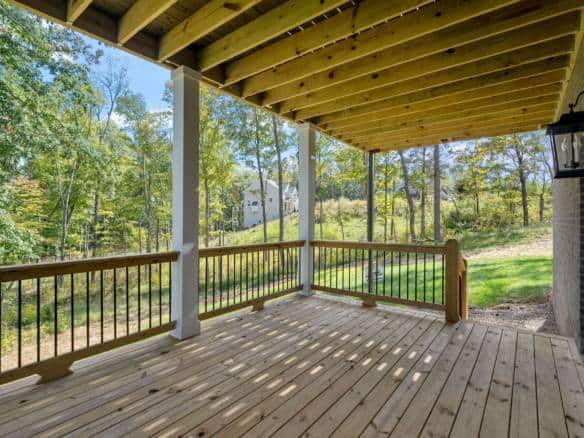 Beautiful wooden deck with railing overlooking lush greenery at 6308 Leyton Court. Perfect outdoor s.