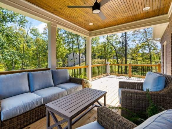 Outdoor porch with comfortable seating and scenic wooded views.