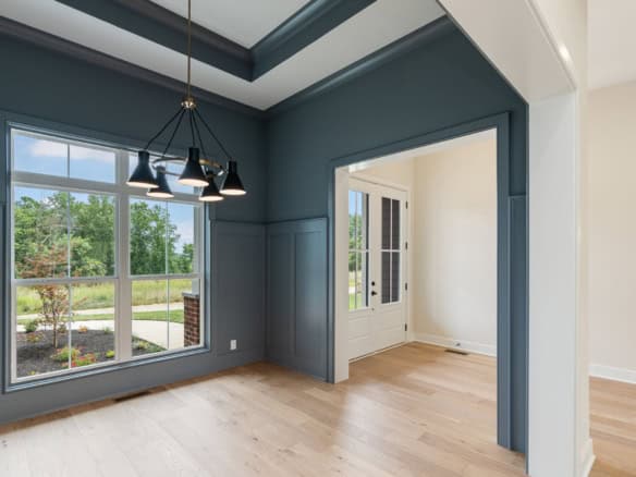Spacious living room featuring large windows, stylish lighting, and contemporary decor.