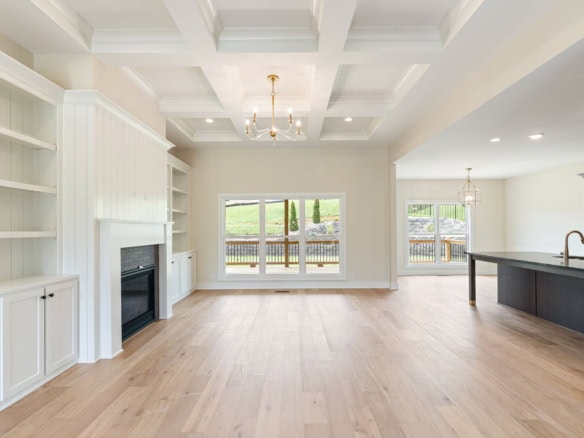 Spacious living area featuring large windows, bright natural light, and stylish ceiling fixtures for.