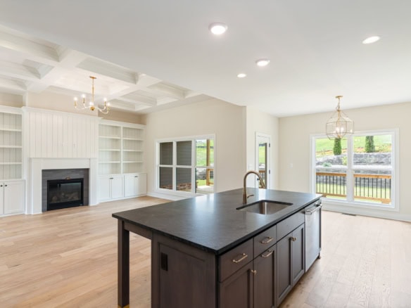 Spacious open-concept kitchen with island and large windows in a newly renovated home.