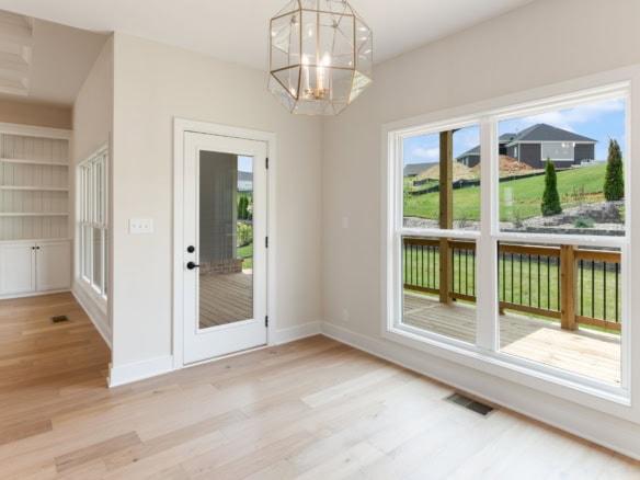 Spacious living area with bright natural light and a stylish chandelier.