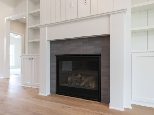 Fireplace with black frame and gray tile surround in a contemporary living room.