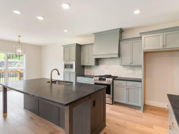 Contemporary kitchen featuring gray cabinets, a large island, and stainless steel appliances.