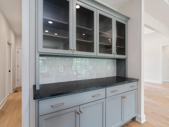 Elegant kitchen cabinetry with glass doors and black granite surface.