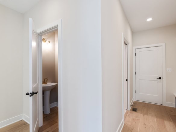 Interior hallway with white walls and natural wood flooring at 6209 Brentwood Dr.