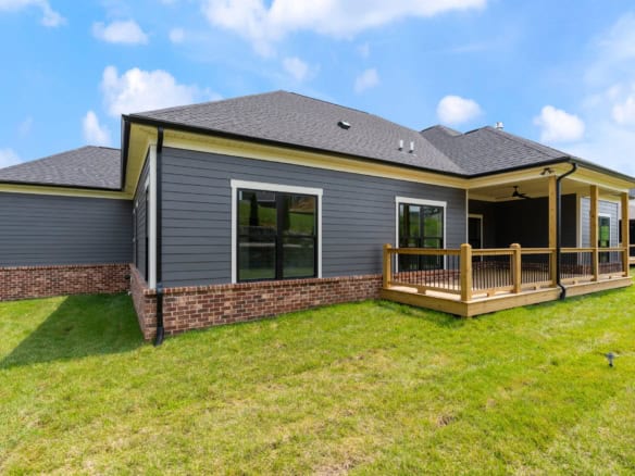 New construction home on Brentwood Dr with backyard deck and gray siding.
