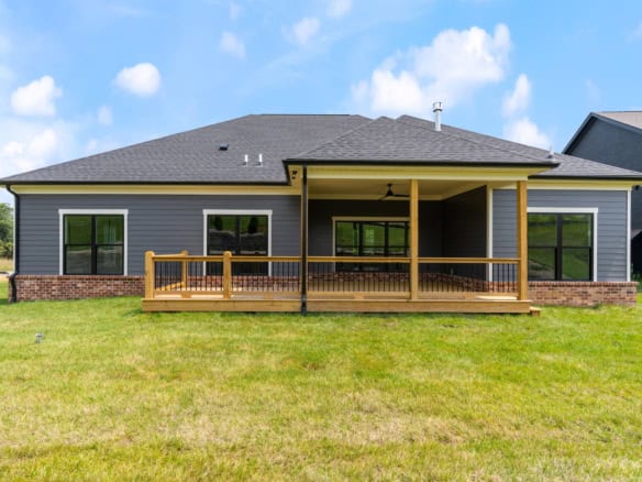 House with gray siding and a large wooden deck for outdoor living.