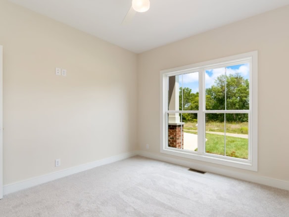 Interior view of a newly built room with large window and neutral walls.