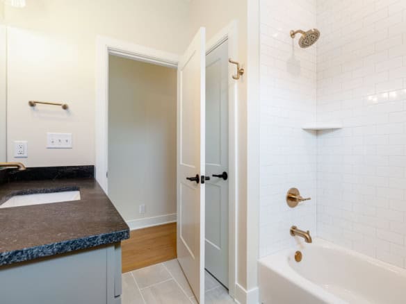 Bright and clean bathroom featuring a white tiled shower and elegant fixtures.