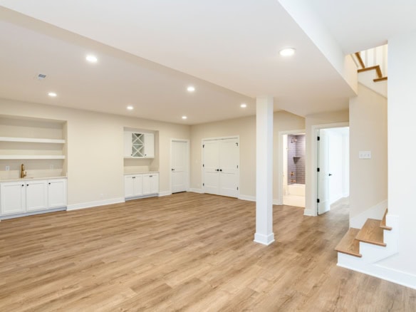 Spacious living room with white built-in shelves and hardwood flooring, part of the new construction.