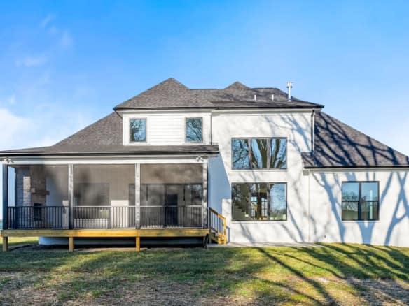 New two-story house with large porch and multiple windows, under construction at Clore Lane.