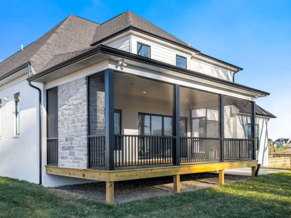 Screened porch with black framing and wooden deck.