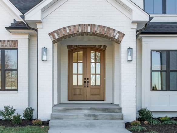 Beautiful new home entrance on Clore Lane with elegant wooden doors and brick accents.