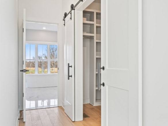 Interior closet with white sliding barn doors and organized shelving at 6286 Clore Lane.