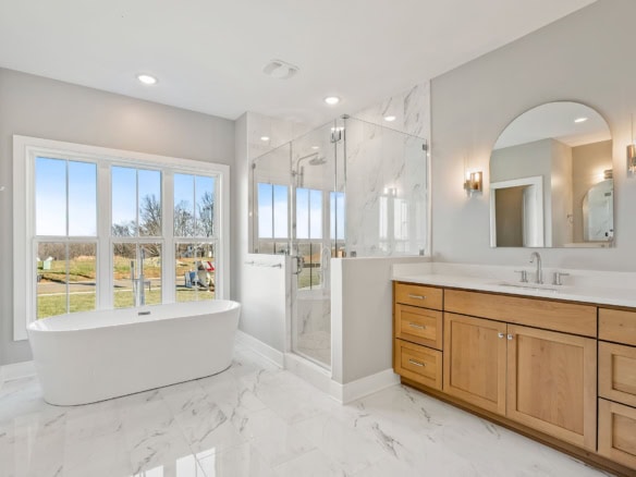 Modern bathroom featuring a freestanding bathtub and a glass-enclosed walk-in shower. Bright, spacio.