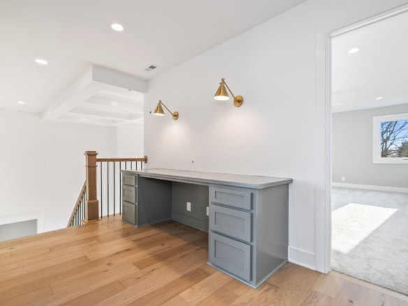 Interior view of a bright, modern home with white walls, wooden flooring, and stylish wall-mounted l.