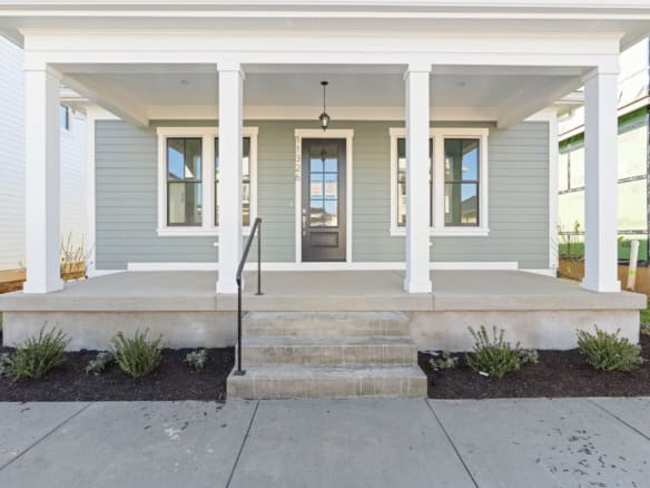 New home front porch with steps, columns, and front door.