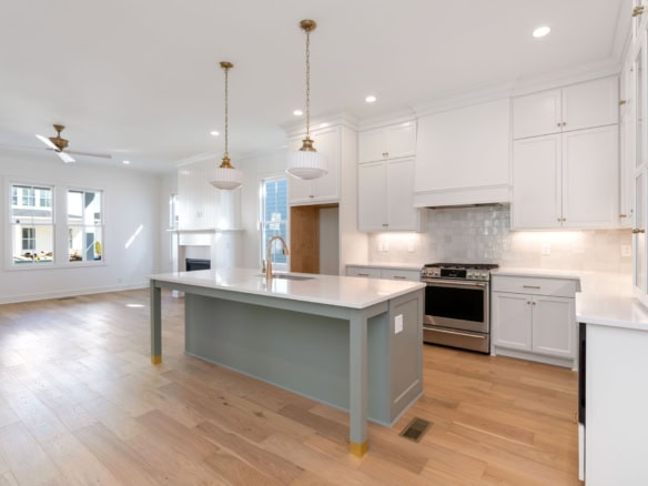 Bright, modern kitchen with white cabinets, island, and open living space.