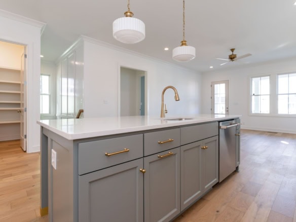 Bright, spacious kitchen with white walls, gray cabinets, and natural light.